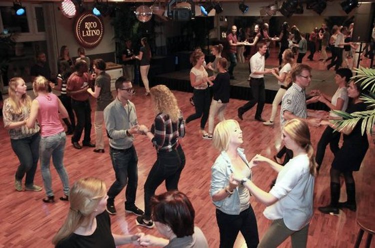 un gruppo di persone ballano in un locale, divertendosi
